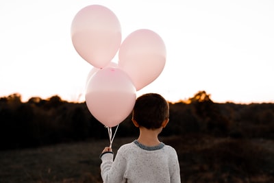 男孩拿着粉色的气球
